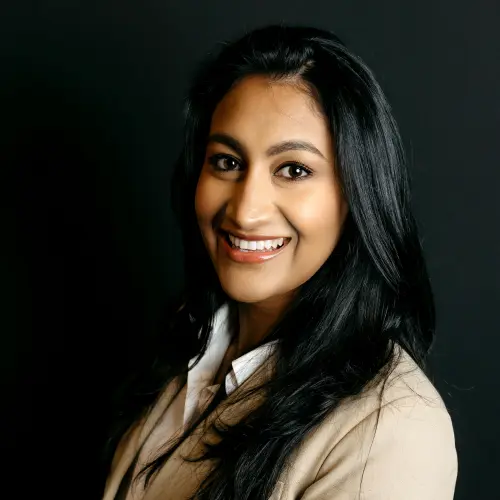 Dr. Malika Jhawar, smiling, in a light jacket.